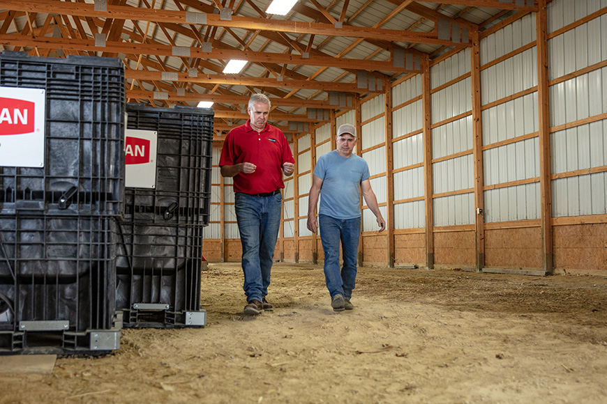 Farmer and CROPLAN retailer walking through a seed shed.